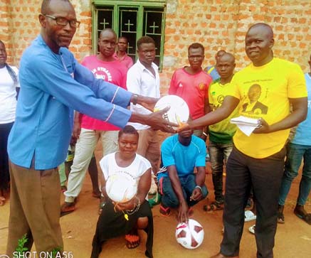 Project manager IYDP handing football for the youth